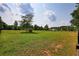 Spacious, grassy backyard with mature trees, a small structure, and perimeter fencing at 3508 Cox Cemetery Rd, Social Circle, GA 30025