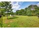 Expansive grassy backyard with fencing, mature trees, and a chicken coop at 3508 Cox Cemetery Rd, Social Circle, GA 30025