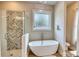 Bathroom with walk-in shower, soaking tub, and a large window with frosted glass at 3508 Cox Cemetery Rd, Social Circle, GA 30025