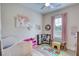A bright bedroom with a crib, play kitchen and table, all on a light wood floor at 3508 Cox Cemetery Rd, Social Circle, GA 30025