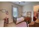 Cozy bedroom with a bed, desk, and closet, complemented by soft pink accents and natural light at 3508 Cox Cemetery Rd, Social Circle, GA 30025