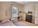 Light-filled bedroom featuring a bed, a wooden dresser, and charming decorative elements for a cozy atmosphere at 3508 Cox Cemetery Rd, Social Circle, GA 30025