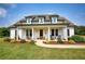 Charming white farmhouse with covered porch, wooden door and manicured front lawn with landscaping at 3508 Cox Cemetery Rd, Social Circle, GA 30025