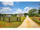 Sprawling farmhouse with a long driveway, fenced yard and large grassy front yard on a sunny day at 3508 Cox Cemetery Rd, Social Circle, GA 30025