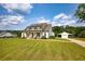 Charming home with a detached garage and portico on a sprawling lawn with a fenced yard and blue sky at 3508 Cox Cemetery Rd, Social Circle, GA 30025