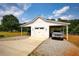 A detached white garage featuring a portico and parking area on a sunny day at 3508 Cox Cemetery Rd, Social Circle, GA 30025
