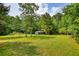 Large grassy field with a storage structure surrounded by lush trees for added privacy at 3508 Cox Cemetery Rd, Social Circle, GA 30025