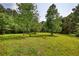 Open grassy area surrounded by mature trees, creating a peaceful and private retreat at 3508 Cox Cemetery Rd, Social Circle, GA 30025