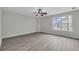 Light-filled bedroom featuring gray laminate floors and modern ceiling fan at 3943 Alexandra Oak Ct, Suwanee, GA 30024