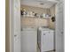 Convenient laundry room with washer, dryer, and shelving for storage at 503 Silver Maple Ln, Woodstock, GA 30189
