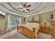 Relaxing main bedroom with a tray ceiling, ceiling fan, and natural light at 503 Silver Maple Ln, Woodstock, GA 30189
