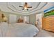 Main bedroom with a tray ceiling, ceiling fan, and ensuite bathroom at 503 Silver Maple Ln, Woodstock, GA 30189