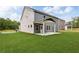 Back exterior of home with covered patio and backyard with lush green grass and partial wooded backdrop at 6104 Marigold Way, Atlanta, GA 30349