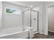 Luxurious bathroom with soaking tub, sleek glass-enclosed shower, marble tiling, and modern fixtures at 6104 Marigold Way, Atlanta, GA 30349