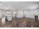 Open-concept living room with hardwood floors, a modern kitchen, and a cozy fireplace at 6104 Marigold Way, Atlanta, GA 30349