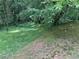 Backyard featuring a freshly mowed lawn, mature trees, and natural landscaping; perfect for outdoor enjoyment at 861 Creek Trail Nw, Kennesaw, GA 30144