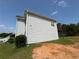 View of the side of the house featuring light siding, a small deck, and a well-maintained lawn at 132 Peggy Meadows Way, Douglasville, GA 30134
