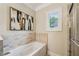 Bright bathroom featuring a tiled jacuzzi tub and a separate glass shower at 261 Elmira Ne Pl, Atlanta, GA 30307