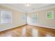 Bright bedroom featuring hardwood floors and three windows providing natural light at 261 Elmira Ne Pl, Atlanta, GA 30307