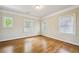 Bright bedroom featuring hardwood floors and three windows providing natural light at 261 Elmira Ne Pl, Atlanta, GA 30307