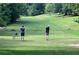 Scenic golf course with lush green fairway, golfer teeing off and a second observing the swing at 261 Elmira Ne Pl, Atlanta, GA 30307