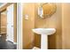 A cozy bathroom with a pedestal sink and a modern mirror at 5575 Wells Circle, Stone Mountain, GA 30087