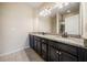 This is a bathroom with a large mirror, granite countertops, dark cabinets, and tile floors at 6404 Brookside Se Blvd, Mableton, GA 30126