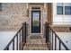 Inviting front entry featuring a black front door, brick steps, and wrought iron railings at 6404 Brookside Se Blvd, Mableton, GA 30126