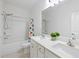 Bright bathroom featuring a double vanity, bathtub with shower, and colorful shower curtain at 1998 Lakeview Bend Way, Buford, GA 30519