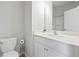 Bathroom featuring white vanity, toilet and mirror with bright overhead lighting at 1998 Lakeview Bend Way, Buford, GA 30519