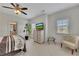 Well-lit bedroom with neutral tones, a ceiling fan, and a cozy sitting area at 406 Fernstone Dr, Canton, GA 30114