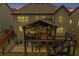 An elegant covered deck featuring stylish seating, a TV, and ambient lighting for evening enjoyment at 406 Fernstone Dr, Canton, GA 30114