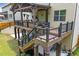 Close-up of a stylish covered deck featuring a dining area, seating, and stairs to a lower level and backyard at 406 Fernstone Dr, Canton, GA 30114