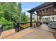 Exterior view of the deck shows built-in outdoor kitchen, seating, and a lush backyard at 406 Fernstone Dr, Canton, GA 30114