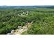 An aerial shot displays the home's placement amidst lush woodlands with a pool nearby at 1703 Rifle Sw Rdg, Marietta, GA 30064