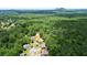 An aerial shot displays the home's placement amidst lush woodlands with a pool nearby at 1703 Rifle Sw Rdg, Marietta, GA 30064