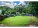 Expansive backyard is perfect for outdoor activities, with a wooden fence, mature trees, and lush green grass for enjoyment at 1703 Rifle Sw Rdg, Marietta, GA 30064