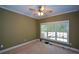 Bright bedroom features a ceiling fan and a large window for natural light at 1703 Rifle Sw Rdg, Marietta, GA 30064