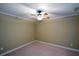 This spare bedroom offers plush carpet, baseboard trim and a ceiling fan at 1703 Rifle Sw Rdg, Marietta, GA 30064