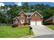 Charming two-story red brick home with a well-manicured lawn, mature trees, and two-car garage at 1703 Rifle Sw Rdg, Marietta, GA 30064