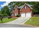 Elegant two-story brick home with a two-car garage and a neatly landscaped front yard on a sloped lot at 1703 Rifle Sw Rdg, Marietta, GA 30064