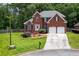 Beautiful two-story brick home featuring a two-car garage, manicured lawn, and mature trees at 1703 Rifle Sw Rdg, Marietta, GA 30064