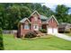 Charming two-story brick home with a manicured lawn, attached two car garage, and inviting curb appeal at 1703 Rifle Sw Rdg, Marietta, GA 30064
