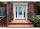 Elegant front entrance featuring a decorative glass door, sidelights, and brick steps with iron railings at 1703 Rifle Sw Rdg, Marietta, GA 30064