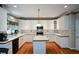 Well-lit kitchen with white cabinets, an island, and stainless steel appliances at 1703 Rifle Sw Rdg, Marietta, GA 30064