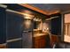 Convenient wet bar in home theater area featuring a sink, granite countertop, and mini fridge for enjoying refreshments during movies at 1703 Rifle Sw Rdg, Marietta, GA 30064