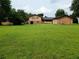 Expansive backyard with lush green lawn and a view of the rear of the house and a detached shed at 2104 Moon Sw Dr, Conyers, GA 30094