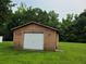 Exterior of a one car detached garage with wood siding and a white garage door on a green lawn at 2104 Moon Sw Dr, Conyers, GA 30094