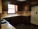 Traditional kitchen with dark wooden cabinets and view of the staircase at 2104 Moon Sw Dr, Conyers, GA 30094