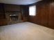Cozy living room with carpet, paneled walls, fireplace, and built-in bookshelves for storage and decor at 2104 Moon Sw Dr, Conyers, GA 30094